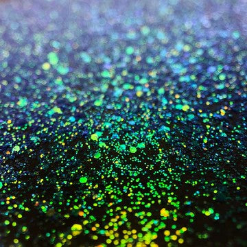 A photo of Dragon Egg Fine Glitter from DreamSQNS scattered on a black surface