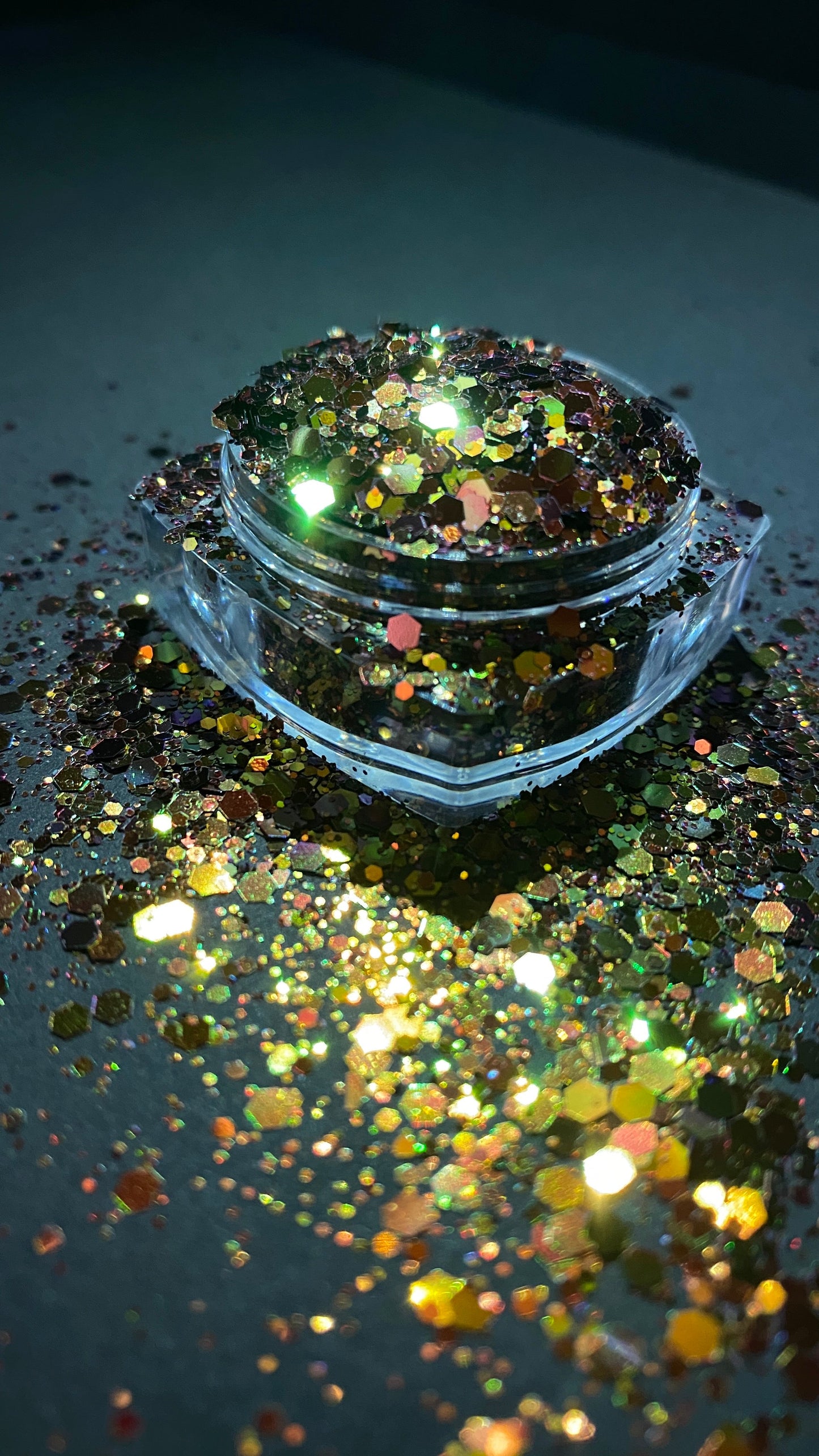 A side view image of Phoenix Chunky Glitter by DreamSQNS in its pot on a black platform