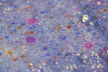A photograph of DreamSQNS Glitter Paste in shade Wisteria spread out on a white platform
