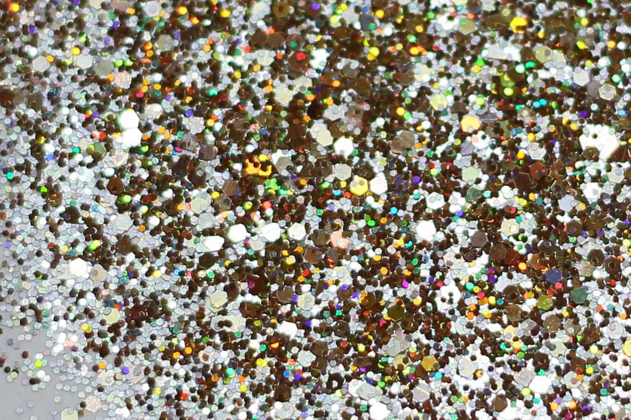 A photograph of Ancient Power Holographic Glitter from DreamSQNS scattered on a white surface