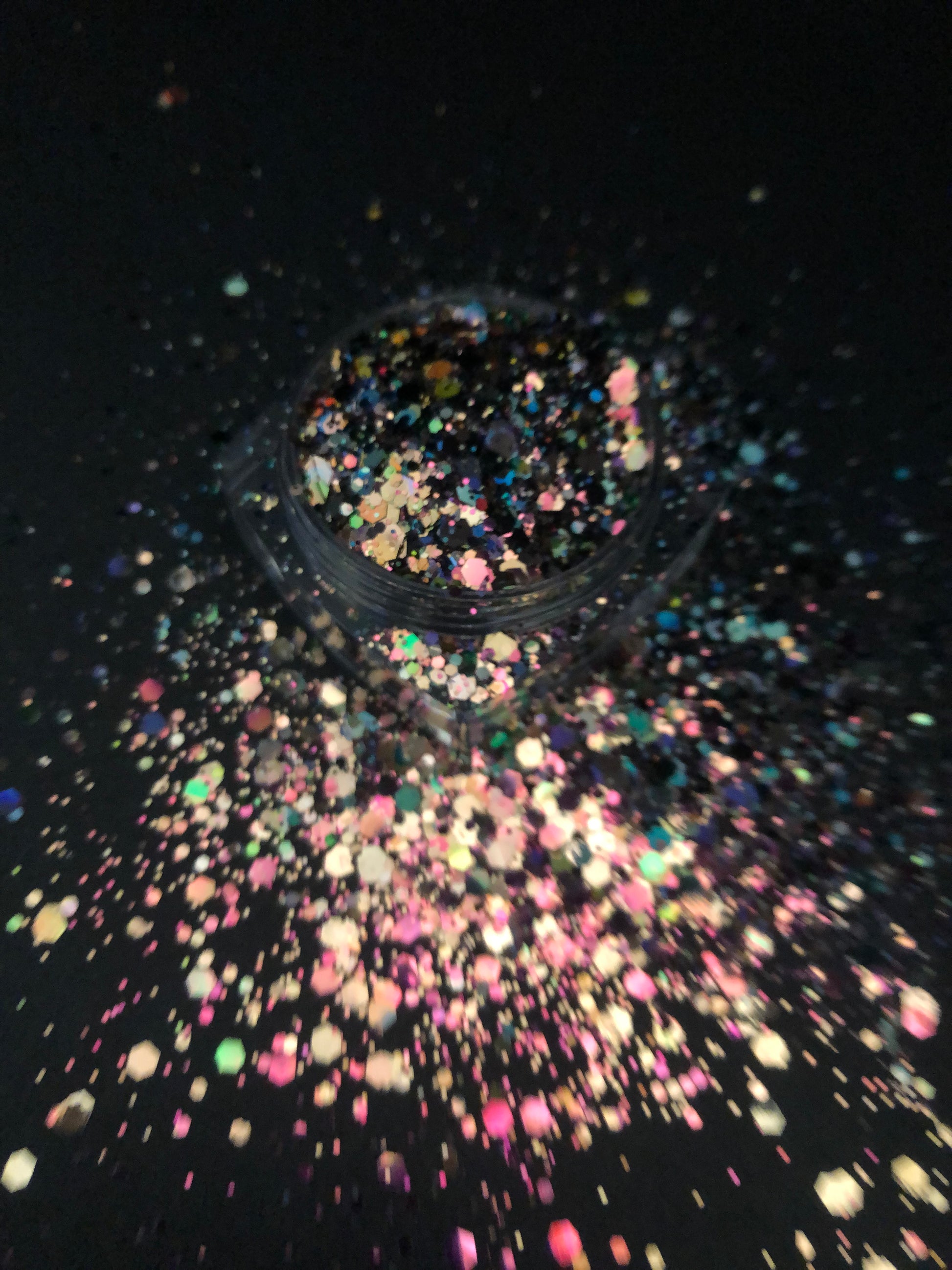 A top view phot of Beetlejuice Chunky Glitter by DreamSQNS in the component and scattered on a black surface