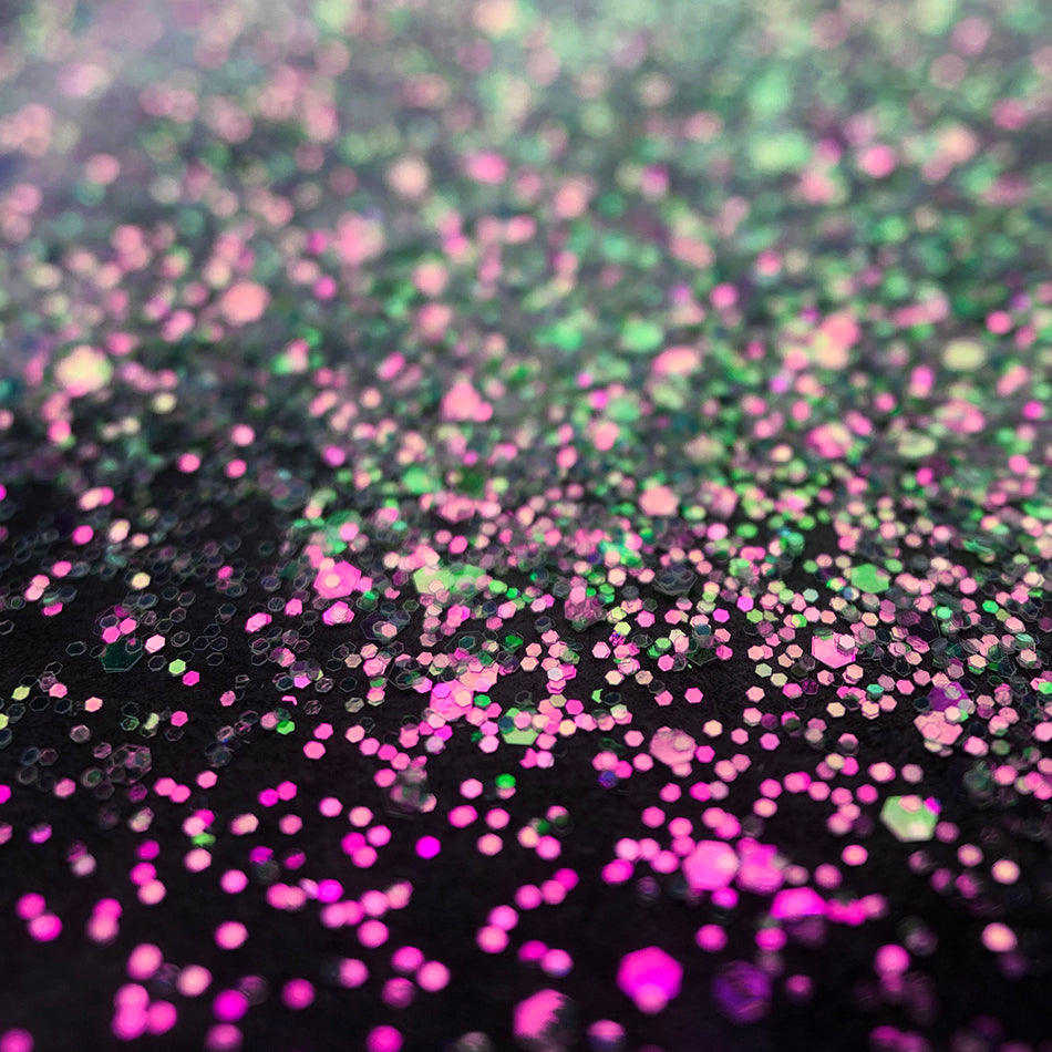 An image of Love Potion Fine Iridescent Glitter by DreamSQNS scattered on a black surface